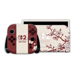 以下が含まれることがあります： ボルドーとクリーム色のNintendo Switchコンソールとコントローラー。コントローラーには「Nintendo Switch」の文字と花の模様があります。コンソールにもお揃いの花の模様があります。
