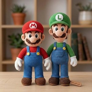 May include: Two crochet dolls representing Mario and Luigi. Mario wears a red cap with an M, red shirt, blue overalls, and brown shoes. Luigi wears a green cap with an L, green shirt, blue overalls, and brown shoes. Both have white gloves.