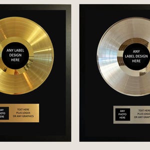 Puede incluir: Dos premios musicales enmarcados con un disco de oro y un disco de plata sobre fondo negro. Cada disco tiene una etiqueta central con el texto ANY LABEL DESIGN HERE. Debajo de cada disco hay una placa rectangular para fotos y texto.