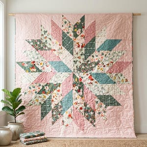 Könnte beinhalten: Ein großer quadratischer Quilt mit einem zentralen Sternmuster aus rautenförmigen Stoffstücken. Das Design enthält florale Drucke in Altrosa, Salbeigrün und Creme, mit aufwendigen Steppnähten, die sich über die gesamte Oberfläche erstrecken.