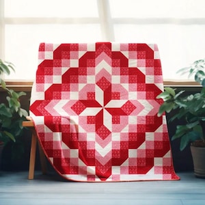 May include: A red and white quilt with a geometric pattern, draped over a wooden bench. The quilt features a central starburst design and a repeating square pattern in shades of red and pink.