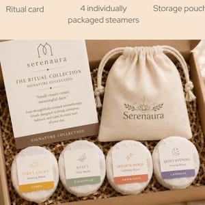 May include: A gift box containing a ritual card, a beige drawstring storage pouch with the Serenaura logo, and four individually wrapped shower steamers labeled First Light, Reset, Golden Hour, and Quiet Evening with scent names.
