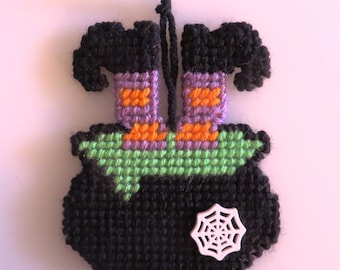 Halloween needlepoint witch in a boiling pot.