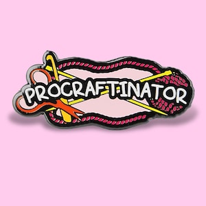May include: A Procraftinator enamel pin with a pink background. The pin features the word "PRODCRAFTINATOR" in white, with a pink and red border. The pin also includes a yellow crochet hook, orange scissors, and a red yarn ball.