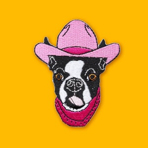 May include: Embroidered patch of a black and white Boston Terrier wearing a pink cowboy hat and a pink bandana.