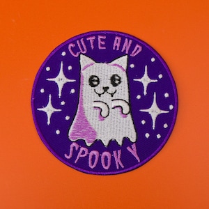 May include: Purple and white embroidered patch featuring a cute ghost and the text "Cute and Spooky".