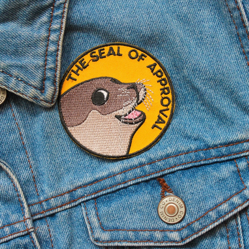 May include: A yellow and brown embroidered patch with a seal and the text "The Seal of Approval".