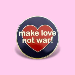 Peut inclure: Une broche émaillée circulaire avec un fond bleu foncé et un cœur rouge au centre. Le texte 'make love not war!' est inscrit en lettres dorées sur le cœur. La broche présente une fine bordure en métal doré sur le pourtour.