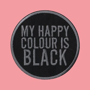 May include: Black and grey embroidered patch with the text "My happy colour is black".