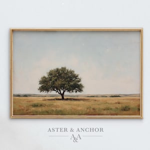 May include: A framed landscape painting featuring a solitary tree in a field. The artwork has a gold frame and depicts a tree with green foliage against a backdrop of a blue sky and golden field. The text "ASTER & ANCHOR" is at the bottom.