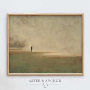 May include: A framed landscape art print featuring a solitary figure in a field. The artwork has a muted color palette of greens, browns, and beige, with a gold-colored frame. The text "ASTER & ANCHOR" is at the bottom.