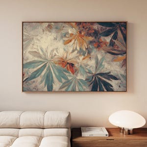 May include: A framed abstract floral painting. The artwork features a mix of colors, including teal, orange, and white, with a focus on large, stylized leaves and flowers. The painting is set in a light-colored wooden frame.