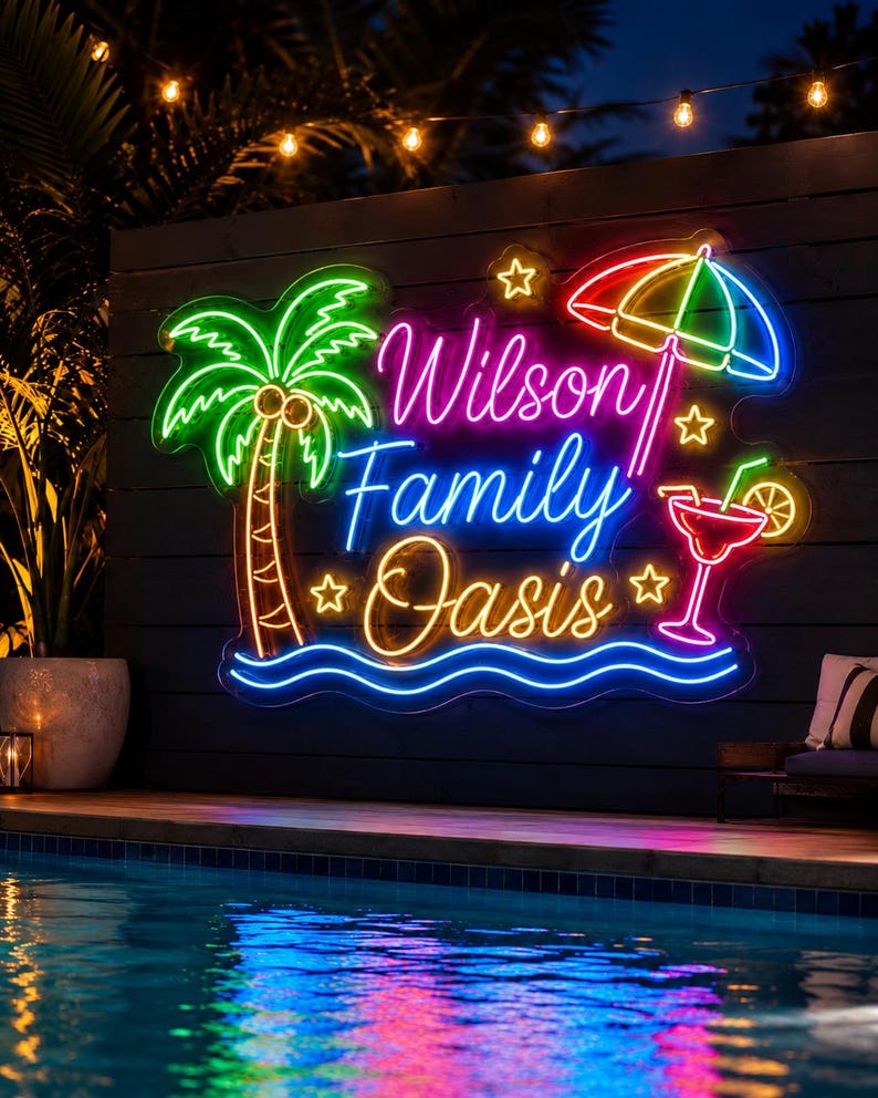 May include: A multi-colored neon sign featuring the text Wilson Family Oasis in script and print lettering. The sign includes a green palm tree, a red and blue beach umbrella, a red cocktail glass with a slice of fruit, and yellow stars.