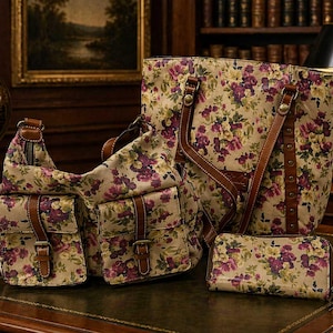 May include: A set of floral print bags and a wallet. The bags include a shoulder bag, a tote bag, and a crossbody bag. The bags and wallet feature a beige background with purple and yellow floral patterns and brown leather accents.