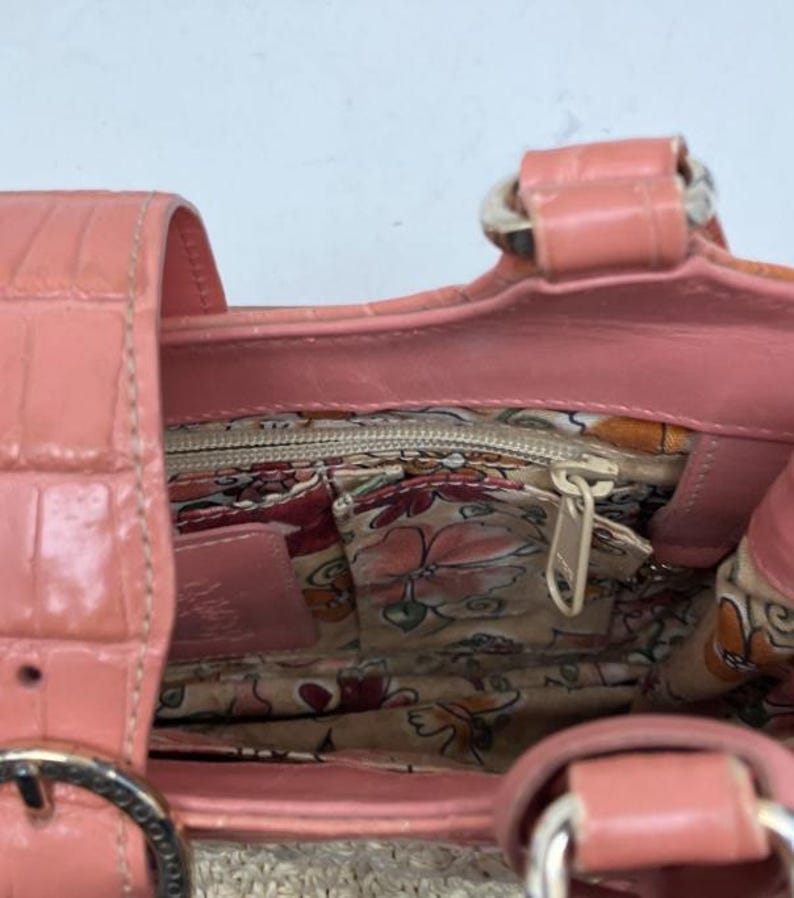 Peut inclure: Un sac &agrave; main corail avec un motif textur&eacute; imitation crocodile. L'int&eacute;rieur pr&eacute;sente une doublure &agrave; imprim&eacute; floral et une poche zipp&eacute;e. Le sac a une base tiss&eacute;e et une poign&eacute;e en cuir corail avec des &eacute;l&eacute;ments m&eacute;talliques.