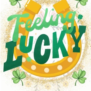 May include: A St. Patrick's Day themed graphic with the words "Feeling Lucky" in green and gold. The word "Feeling" is in a script font, and "Lucky" is in a bold, block font. A gold horseshoe and shamrocks complete the design.