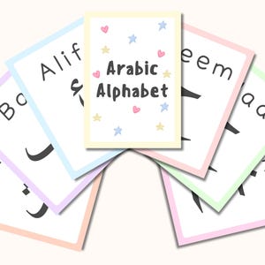 Puede incluir: Tarjetas didácticas con el alfabeto árabe. Cada tarjeta tiene un borde pastel y muestra una letra negra. Una tarjeta central dice "Arabic Alphabet" con decoraciones de corazones y estrellas.