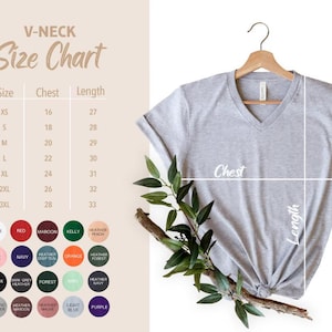 May include: A light gray V-neck t-shirt hanging on a wooden hanger, with a size chart and color options displayed. The size chart shows chest and length measurements in inches. The text "V-NECK Size Chart" is at the top.