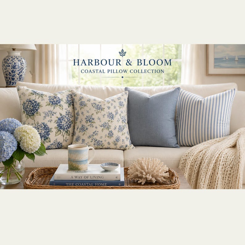 May include: Four square throw pillows arranged on a sofa, featuring two floral patterns with blue hydrangeas, one solid blue, and one blue and white striped pillow. Text reads HARBOUR & BLOOM COASTAL PILLOW COLLECTION above the pillows.