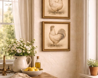 May include: Two framed vintage-style prints of a chicken and a rooster hang on a textured wall. The prints have gold frames. A white pitcher with flowers, a bowl of lemons, and a bottle of oil sit on a wooden countertop.