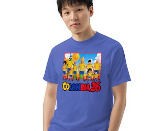 May include: Blue t-shirt featuring a graphic of a soccer team with yellow and blue uniforms. The graphic includes the text "COLOMBIA 26" in a colorful font. The shirt is made of a soft material.