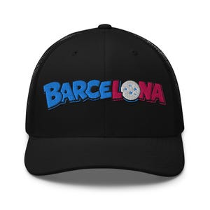 Puede incluir: Gorra de camionero negra con la palabra "BARCELONA" bordada en azul y rojo. La gorra tiene una parte trasera de malla y una visera curva. La palabra "BARCELONA" está en una fuente audaz y estilizada.