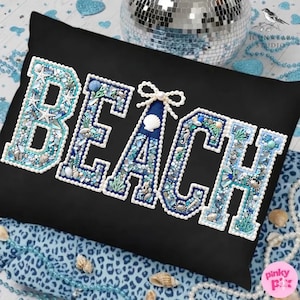 May include: Black pillow with the word "BEACH" in white, blue, and turquoise. The letters are decorated with seashells, starfish, and pearls. The pillow is on a blue leopard print fabric.