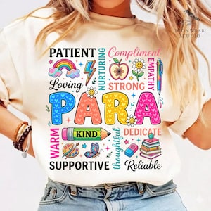 May include: Cream-colored t-shirt with a colorful graphic design. The design features the word "PARA" in large, multi-colored letters, surrounded by words like "Loving," "Kind," and "Supportive," along with illustrations of a rainbow, pencil, and books.