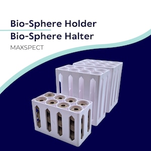 May include: White plastic Bio-Sphere Holder and Bio-Sphere Halter with MAXSPECT text. The holders are rectangular with multiple circular openings, containing brown spheres. The background is dark blue with a white and teal curved design.