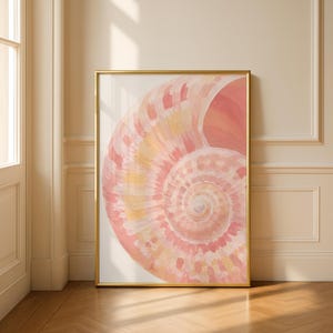 Könnte beinhalten: Ein gerahmter Kunstdruck mit einer Aquarellmalerei einer Nautilusmuschel. Die Muschel ist in Rosa-, Pfirsich- und Gelbtönen gehalten und weist ein spiralförmiges Muster auf. Der goldene Rahmen verleiht dem Kunstwerk einen Hauch von Eleganz.