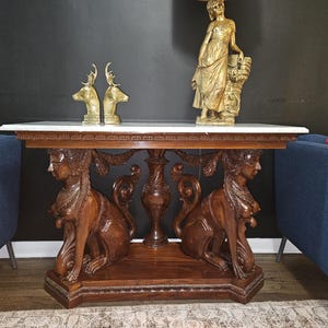 Consola antigua de caoba: base con esfinge de estilo neoegipcio, tablero de mármol.