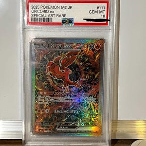 Könnte beinhalten: Eine bewertete Pokémon-Karte mit einer lebendigen Illustration von Oricorio ex. Die Karte ist in einem Schutzhalter eingeschlossen, der angibt, dass es sich um eine Special Art Rare handelt, bewertet mit GEM MT 10. Das Artwork der Karte zeigt ein feuriges, detailliertes Design.