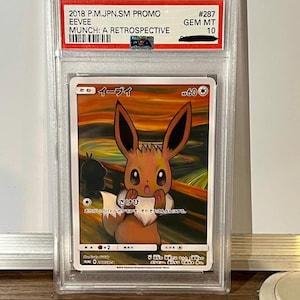 Peut inclure: Une tasse en céramique blanche avec une anse noire et l'inscription "But First, Coffee" en gras noir. La tasse est posée sur un fond flou, suggérant un cadre chaleureux.