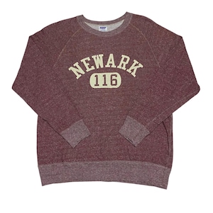May include: Maroon crewneck sweatshirt with the word "NEWARK" arched across the chest in off-white lettering, with the number "116" below. The sweatshirt has raglan sleeves and ribbed cuffs and hem. The fabric has a heathered texture.