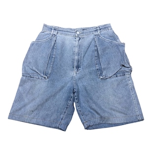 Puede incluir: Pantalones cortos de mezclilla azul claro con diseño de cintura alta, cierre de botón y cremallera. Estos pantalones incluyen dos bolsillos grandes y prominentes en la parte delantera, cintura estructurada con trabillas y corte recto.