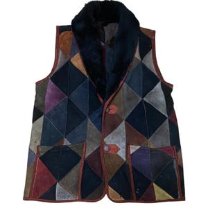 May include: A vintage patchwork vest with a black faux fur collar. The vest is patterned with geometric shapes in a variety of colours, including black, brown, red, and purple. It has two pockets and two buttons.