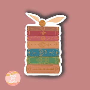 May include: A stack of seven colorful books with gold accents and illustrations. The books are topped with a golden snitch and a pair of golden wings.