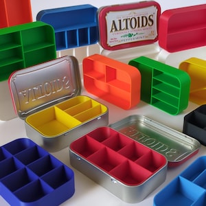May include: A collection of colorful, repurposed Altoids tins and custom-made plastic inserts. The tins are silver and red, with the Altoids logo visible. The inserts are in various colors, including red, yellow, green, blue, and orange, and are designed to organize small items.