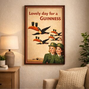 May include: A framed vintage-style Guinness advertisement. The artwork features toucans carrying pints of Guinness, with the text "Lovely day for a Guinness." Two women in green uniforms are also depicted.