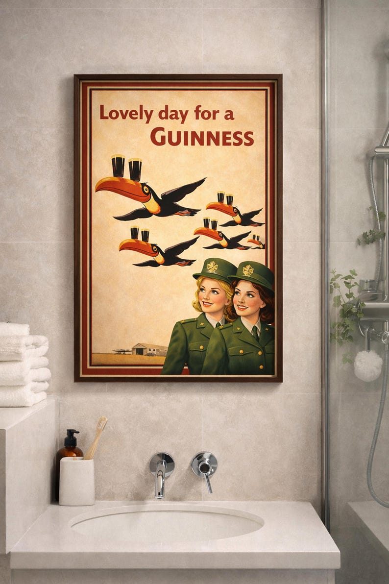 May include: Framed vintage-style Guinness advertisement. The artwork features toucans carrying pints of Guinness, with the text "Lovely day for a Guinness." Two women in green uniforms are also depicted.