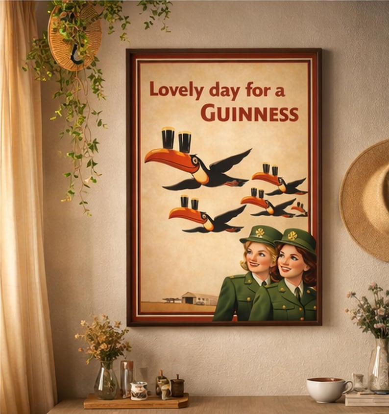 May include: Framed print with the text "Lovely day for a Guinness." The artwork features toucans carrying pints of Guinness, with two women in green uniforms below. The background is a light tan color.