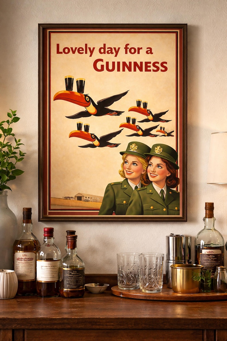 May include: Framed vintage-style Guinness advertisement featuring toucans carrying pints of Guinness. The poster has the text "Lovely day for a Guinness" and depicts two women in green uniforms. The image is displayed on a wooden surface with bottles and glasses.