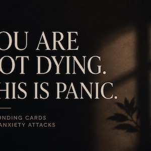 May include: A dark rectangular card featuring the beige text YOU ARE NOT DYING. THIS IS PANIC. followed by a horizontal line and the smaller text GROUNDING CARDS FOR ANXIETY ATTACKS. The right side shows a soft shadow of a plant against a dark background.