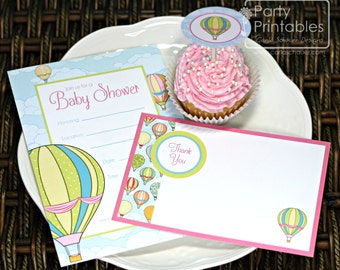 May include: A set of printable baby shower invitations and thank you cards featuring a hot air balloon theme. The invitations are light blue with white clouds and hot air balloons in various colours. The thank you cards are pink with a white border and a single hot air balloon.