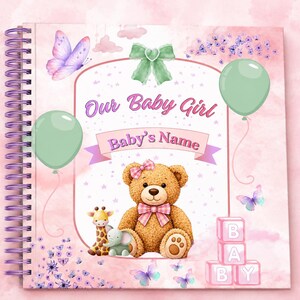 May include: A spiral-bound scrapbook with a pink watercolor background featuring a teddy bear, a giraffe, an elephant, butterflies, and green balloons. The cover displays the text Our Baby Girl and Baby's Name with pink and white alphabet blocks.