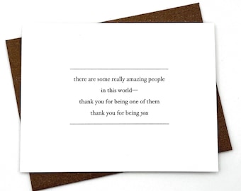 Puede incluir: Una tarjeta de felicitación blanca con texto en negro que dice: there are some really amazing people in this world— thank you for being one of them thank you for being you. La tarjeta está sobre un sobre marrón con acabado texturizado.