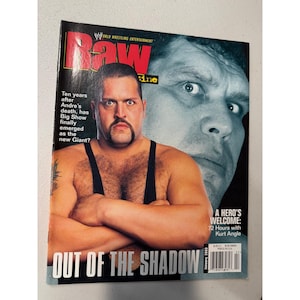 Puede incluir: Una revista WWE Raw de enero de 2003 con Big Show en la portada. La portada incluye el texto "Out of the Shadow" y "A Hero's Welcome: 72 Hours with Kurt Angle."