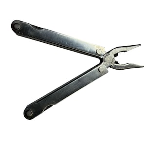 May include: A silver-coloured stainless steel multi-tool featuring needle-nose pliers at the head. The tool has two long, flat handles that are partially open, revealing a pivot point with the embossed text LEATHERMAN TOOL.