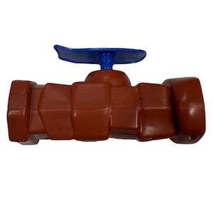 May include: A brown plastic ball valve featuring a horizontal body with a segmented, block-like design and a bright blue lever handle positioned on top. The valve has a smooth, molded finish and a distinct mechanical structure for fluid control.