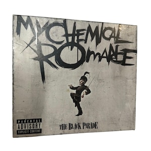 May include: A square music album cover featuring the text My Chemical Romance in large black brush-style lettering at the top. Below is a small illustration of a figure in a marching band uniform. The text The Black Parade and a Parental Advisory label appear.